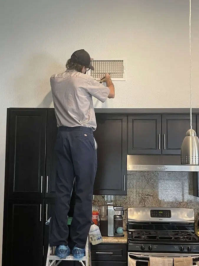Technician inspecting an air vent during HVAC service in Bucksport